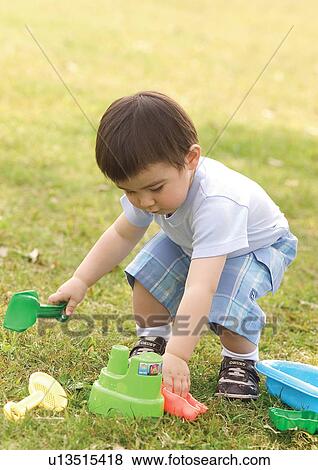 Side profile of a boy bending to pick up toys View Large Photo Image Stock Photo - Side profile of a boy bending to pick up toys. Fotosearch