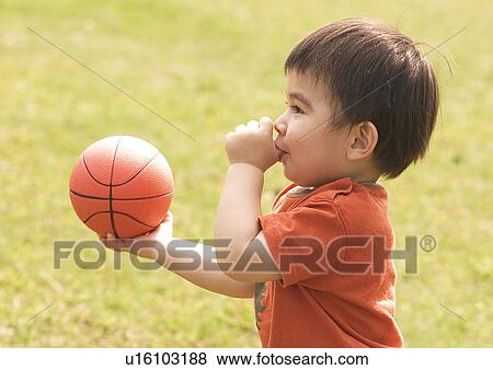 Side profile of a boy holding a basketball and sucking his thumb View Large Photo Image Stock Photo - Side profile of a boy holding a basketball and sucking his thumb. Fotosearch