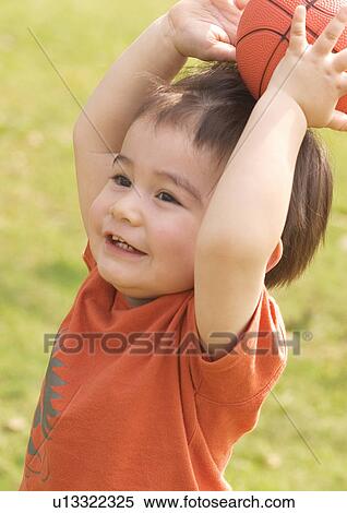 Side profile of a boy holding a basketball on his head View Large Photo Image Stock Photography - Side profile of a boy holding a basketball on his head. Fotosearch