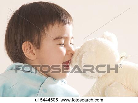 Stock Photography - Side profile of a boy nuzzling a stuffed toy. Fotosearch