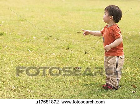 Side profile of a boy standing in a lawn and pointing View Large Photo Image Stock Image - Side profile of a boy standing in a lawn and pointing. Fotosearch