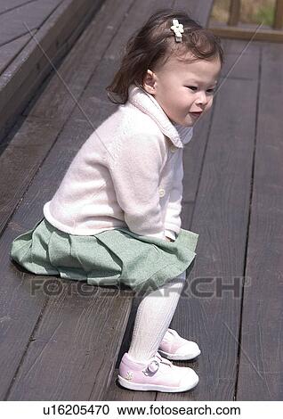 Side profile of a girl sitting on a wooden bench View Large Photo Image Stock Image - Side profile of a girl sitting on a wooden bench. Fotosearch
