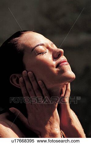 Stock Photography - indulgence, eyes closed, pampering, sunlight, young adult, head and shoulders. Fotosearch