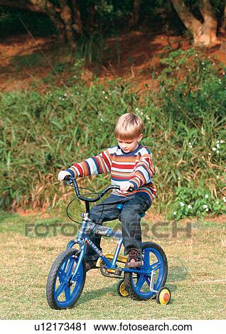 Stock Image - day, innocence, shoe, lifestyle, cycle, young boy. Fotosearch