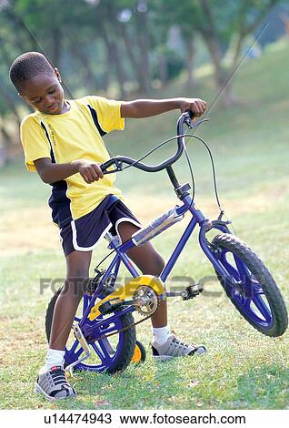 Stock Image - grass, carefree, trees, happy, cycle, lifestyle, smiling. Fotosearch