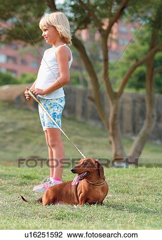 Stock Image - happy, cheerful, holding, carefree, grass, standing. Fotosearch