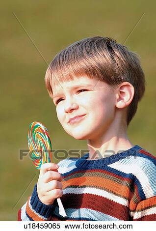Stock Photography - young boy, happiness, looking up, casual, close-up, grass. Fotosearch
