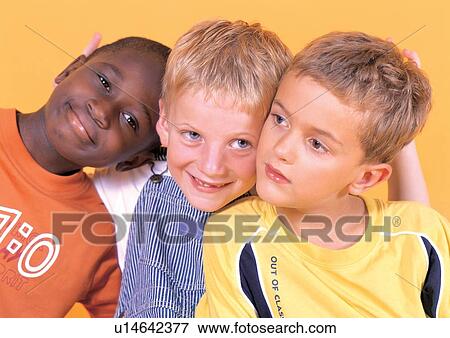 Stock Photo - casual, youth, three people, happy, standing, young boy, indoor. Fotosearch
