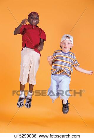 Stock Photograph - cheerful, friends, indoor, jumping, close-up, smiling, child. Fotosearch