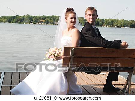 Stock Image - Back To Back, Brown Hair, Bride, Bench, Adults Only. Fotosearch