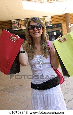 Stock Image - Woman, Shopping, Casual wear, T shirt, Skirt, Sunglasses, Blond. Fotosearch
