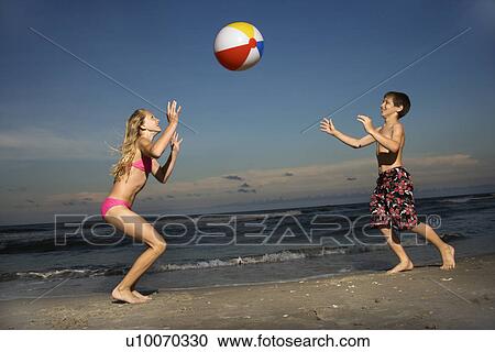 Caucasian pre-teen girl and boy playing with beachball on beach. View Large Photo Image Stock Image - Caucasian pre-teen girl and boy playing with beachball on beach.. Fotosearch