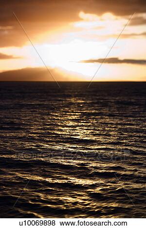 Stock Photo - Sunset view of ocean and Kihei island in Maui, Hawaii, USA.. Fotosearch