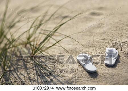 Two white sandals on sandy beach. View Large Photo Image Picture - Two white sandals on sandy beach.. Fotosearch