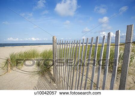 Stock Photo - Weathered wooden fence on sand dune.. Fotosearch