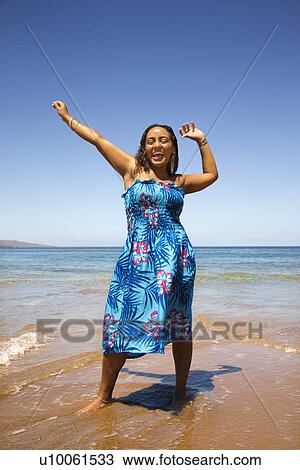 Yound-adult Black woman standing in shore with arms stretched. View Large Photo Image Stock Image - Yound-adult Black woman standing in shore with arms stretched.. Fotosearch