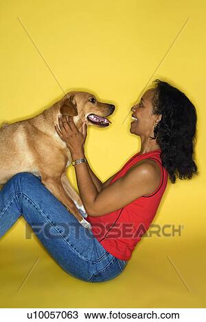 Stock Image - African American prime adult female with dog.. Fotosearch