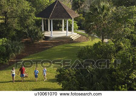 Caucasian family of four walking in park carrying picnic basket. View Large Photo Image Stock Image - Caucasian family of four walking in park carrying picnic basket.. Fotosearch