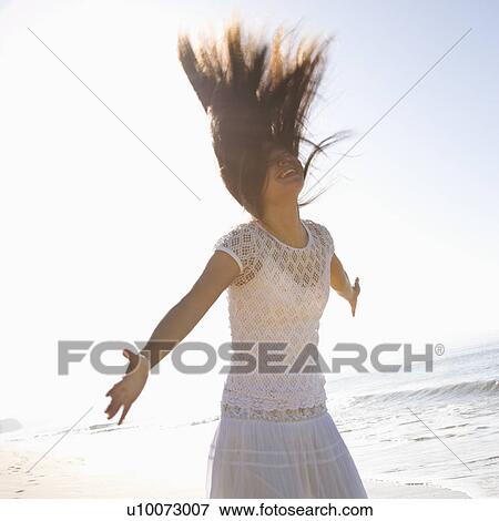 Young adult Asian female with arms outward and throwing hair back. View Large Photo Image Stock Photo - Young adult Asian female with arms outward and throwing hair back.. Fotosearch