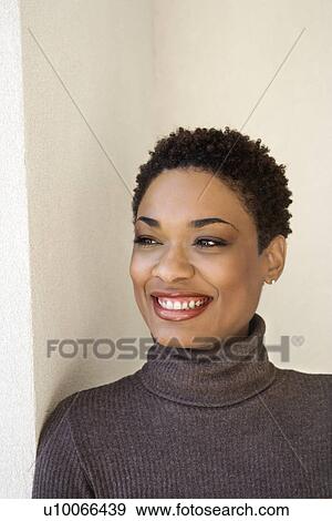 Close up of African- American woman leaning against wall smiling looking out to side. View Large Photo Image Stock Photo - Close up of African- American woman leaning against wall smiling looking out to side.. Fotosearch