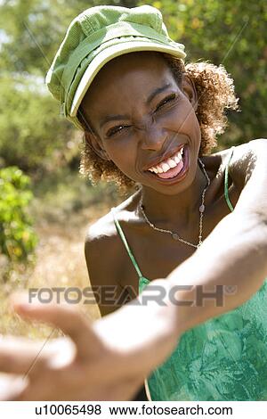 Mid-adult Black female smiling with hand reaching out towards camera. View Large Photo Image Stock Photo - Mid-adult Black female smiling with hand reaching out towards camera.. Fotosearch