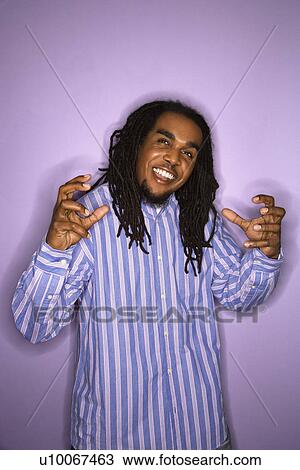 Smiling African-American mid-adult man on purple background with hands gesturing. View Large Photo Image Stock Image - Smiling African-American mid-adult man on purple background with hands gesturing.. Fotosearch