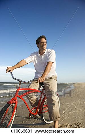 Caucasian mid-adult man posing on bicycle on beach. View Large Photo Image Stock Image - Caucasian mid-adult man posing on bicycle on beach.. Fotosearch