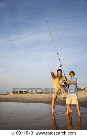 Caucasian mid-adult man shore fishing on beach with pre-teen boy and pointing. View Large Photo Image Stock Image - Caucasian mid-adult man shore fishing on beach with pre-teen boy and pointing.. Fotosearch