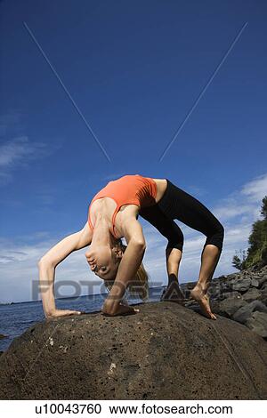 Caucasian young adult woman doing yoga on rocky shore. View Large Photo Image Stock Image - Caucasian young adult woman doing yoga on rocky shore.. Fotosearch