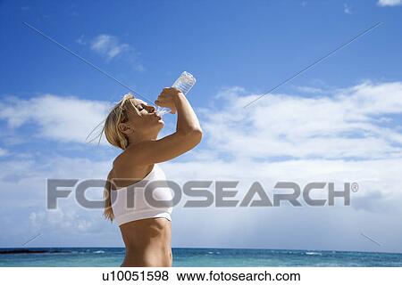 Caucasian young adult woman drinking water on beach. View Large Photo Image Stock Photo - Caucasian young adult woman drinking water on beach.. Fotosearch