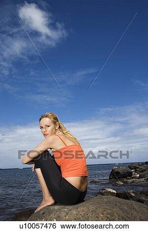 Caucasian young adult woman sitting on rocky shore. View Large Photo Image Stock Photograph - Caucasian young adult woman sitting on rocky shore.. Fotosearch