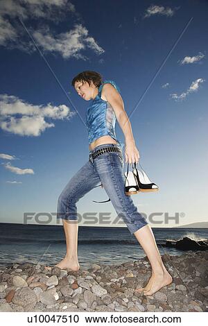 Caucasian young female adult walking barefoot on rocky shore. View Large Photo Image Stock Image - Caucasian young female adult walking barefoot on rocky shore.. Fotosearch