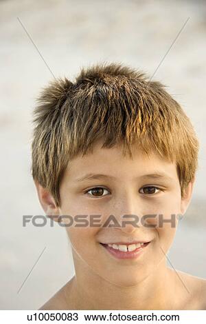Stock Image - Portrait of smiling Caucasian pre-teen boy on beach.. Fotosearch