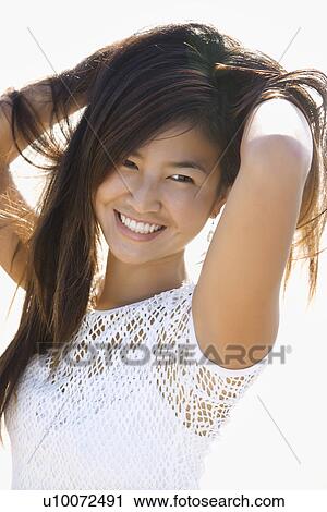 Portrait of young Asian female holding hair up behind her back. View Large Photo Image Stock Image - Portrait of young Asian female holding hair up behind her back.. Fotosearch