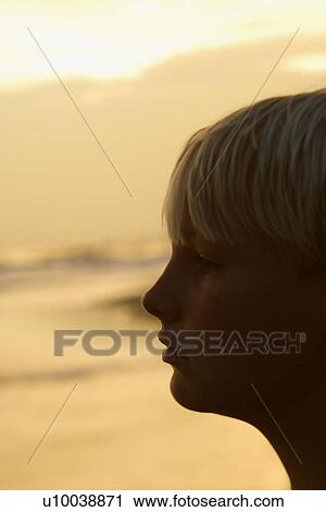 Profile of caucasian pre-teen boy on beach at sunset. View Large Photo Image Stock Image - Profile of caucasian pre-teen boy on beach at sunset.. Fotosearch