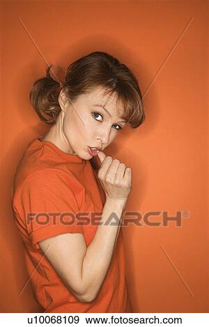 Caucasian mid-adult woman gesturing with thumb on orange background. View Large Photo Image Stock Photo - Caucasian mid-adult woman gesturing with thumb on orange background.. Fotosearch