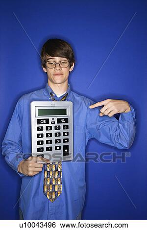 Portrait of Caucasian teen boy holding and pointing to oversized calculator. View Large Photo Image Stock Photograph - Portrait of Caucasian teen boy holding and pointing to oversized calculator.. Fotosearch