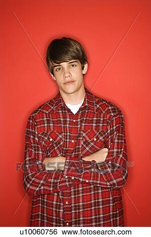Portrait of Caucasian teen boy with arms crossed standing against red background wearing flannel shirt. View Large Photo Image Stock Photograph - Portrait of Caucasian teen boy with arms crossed standing against red background wearing flannel shirt.. Fotosearch