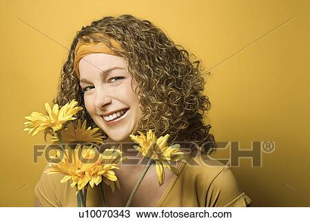 Portrait of smiling young adult Caucasian woman on yellow background holding bouquet of flowers. View Large Photo Image Stock Image - Portrait of smiling young adult Caucasian woman on yellow background holding bouquet of flowers.. Fotosearch