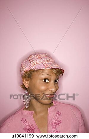 Portrait of young African-American woman on pink background with comical expression on her face. View Large Photo Image Stock Photo - Portrait of young African-American woman on pink background with comical expression on her face.. Fotosearch