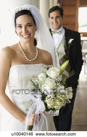 Caucasian mid-adult bride and groom standing on porch looking at viewer and smiling. View Large Photo Image Stock Photograph - Caucasian mid-adult bride and groom standing on porch looking at viewer and smiling.. Fotosearch