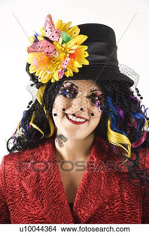 Picture - Caucasian woman in unique makeup and clothing standing against white background.. Fotosearch
