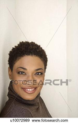 Stock Photo - Close up of African- American woman looking at viewer smiling.. Fotosearch