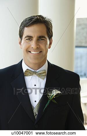 Stock Image -  Portrait of Caucasian mid-adult groom in tuxedo smiling.. Fotosearch