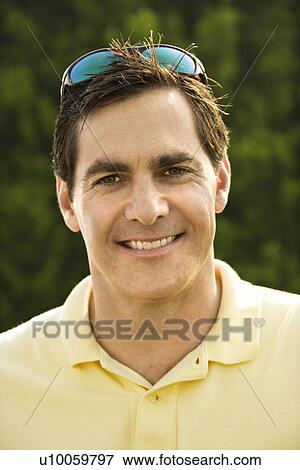 Stock Photo - Portrait of Caucasian mid-adult man smiling at camera.. Fotosearch