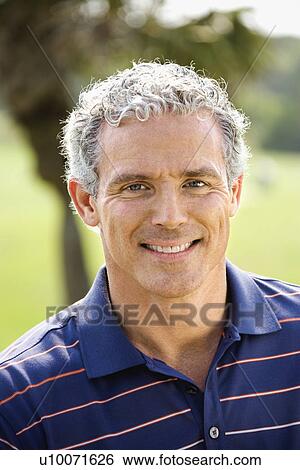 Stock Photograph - Portrait of Caucasion mid-adult man smiling and looking at viewer.. Fotosearch