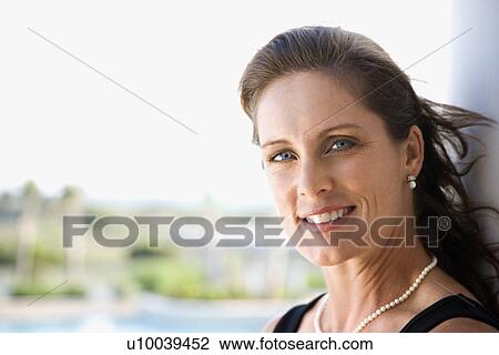 Stock Image - Portrait of mid-adult Caucasian female looking making eye contact.. Fotosearch