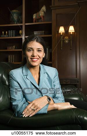 Stock Photography - Prime adult Hispanic female sitting looking at viewer smiling.. Fotosearch