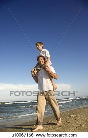 Caucasian father with pre-teen boy on shoulders on beach. View Large Photo Image Stock Photograph - Caucasian father with pre-teen boy on shoulders on beach.. Fotosearch