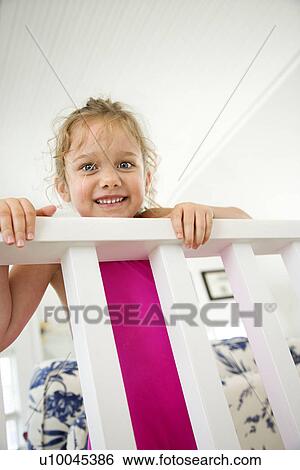 Stock Photograph - Caucasian female child peeking over railing.. Fotosearch